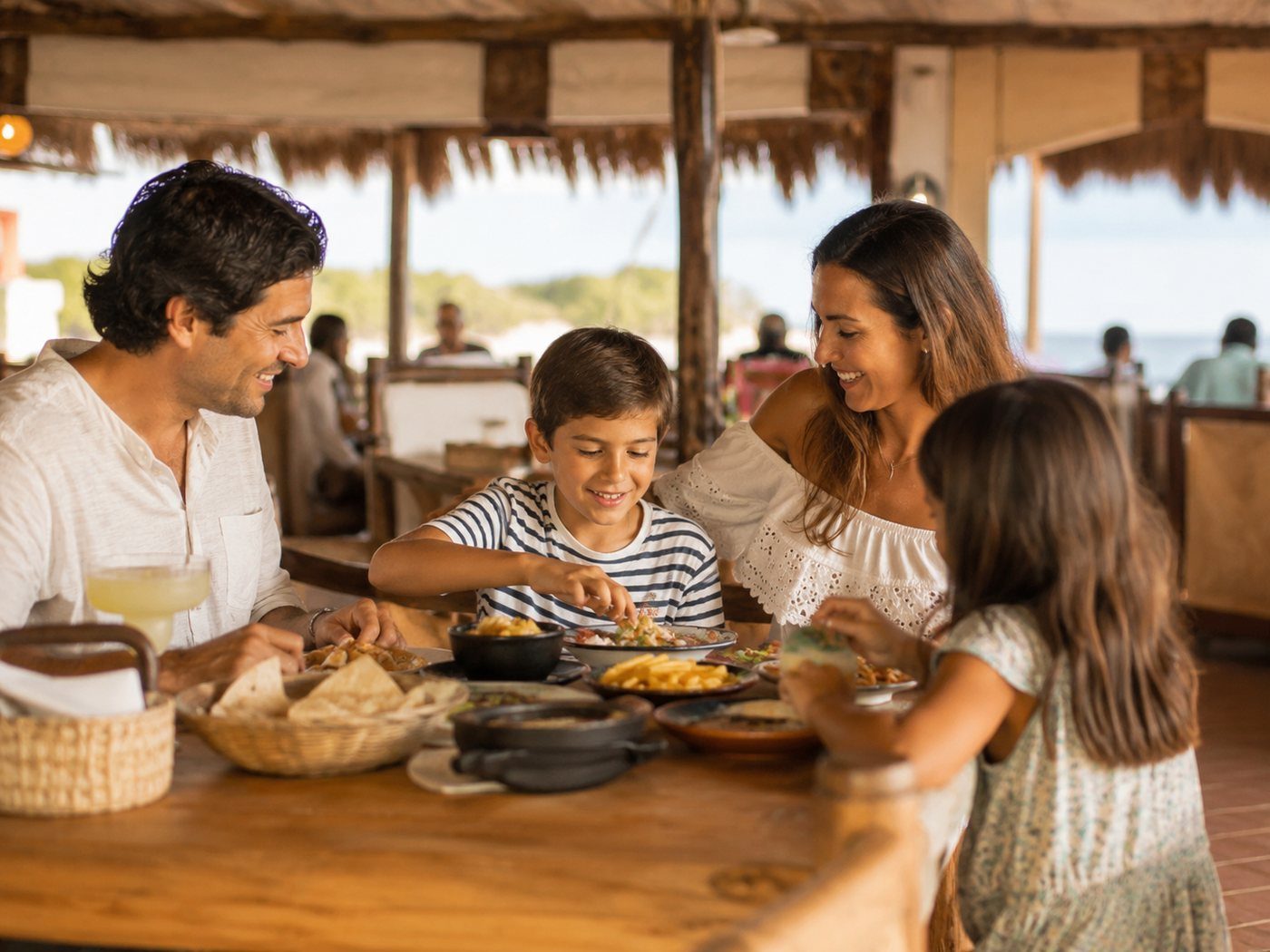 A family sharing a relaxed early dinner at a Cancún restaurant.