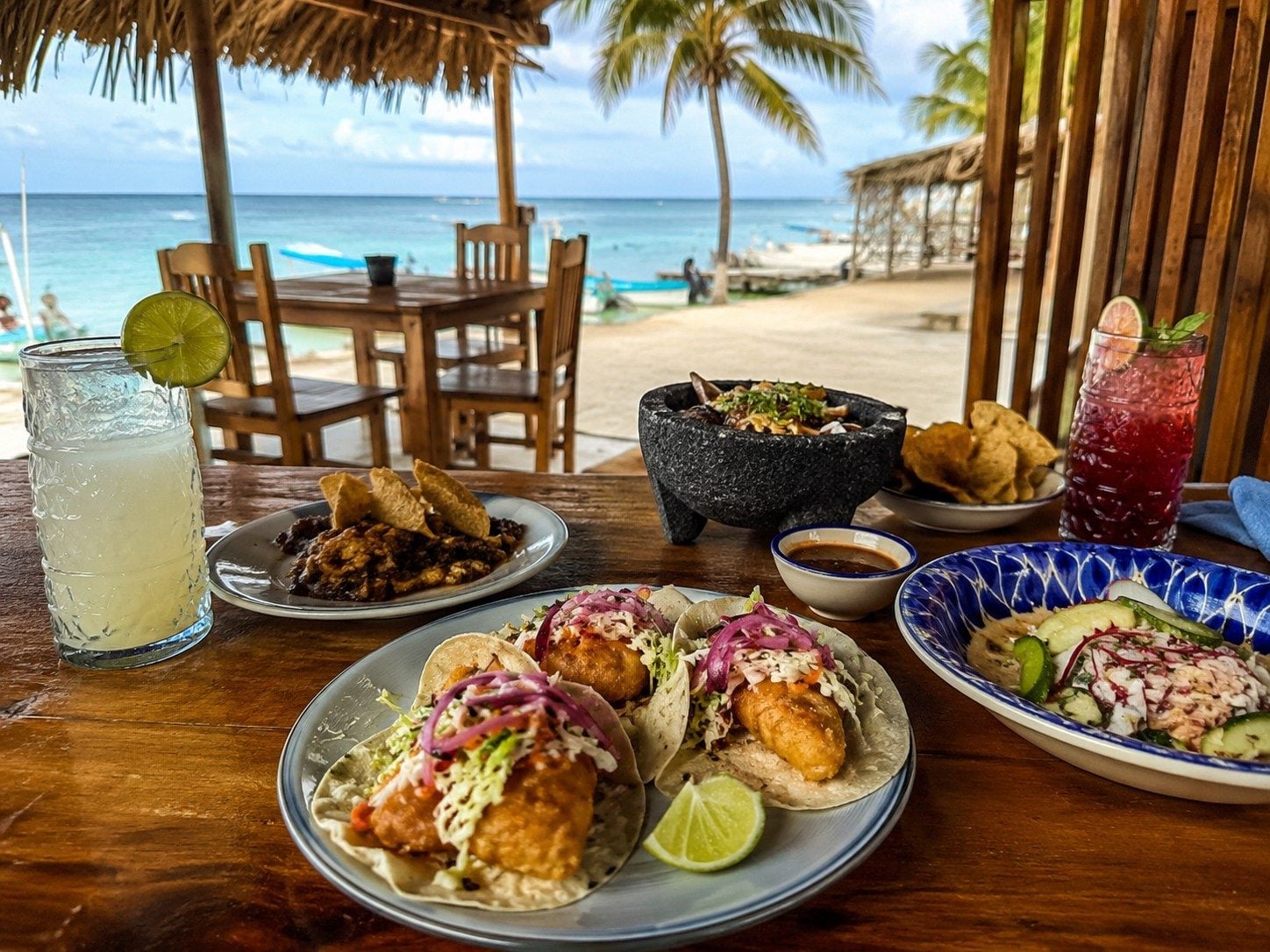 An evening taco stand in the Puerto Morelos Colonia with a visible menu and local customers.