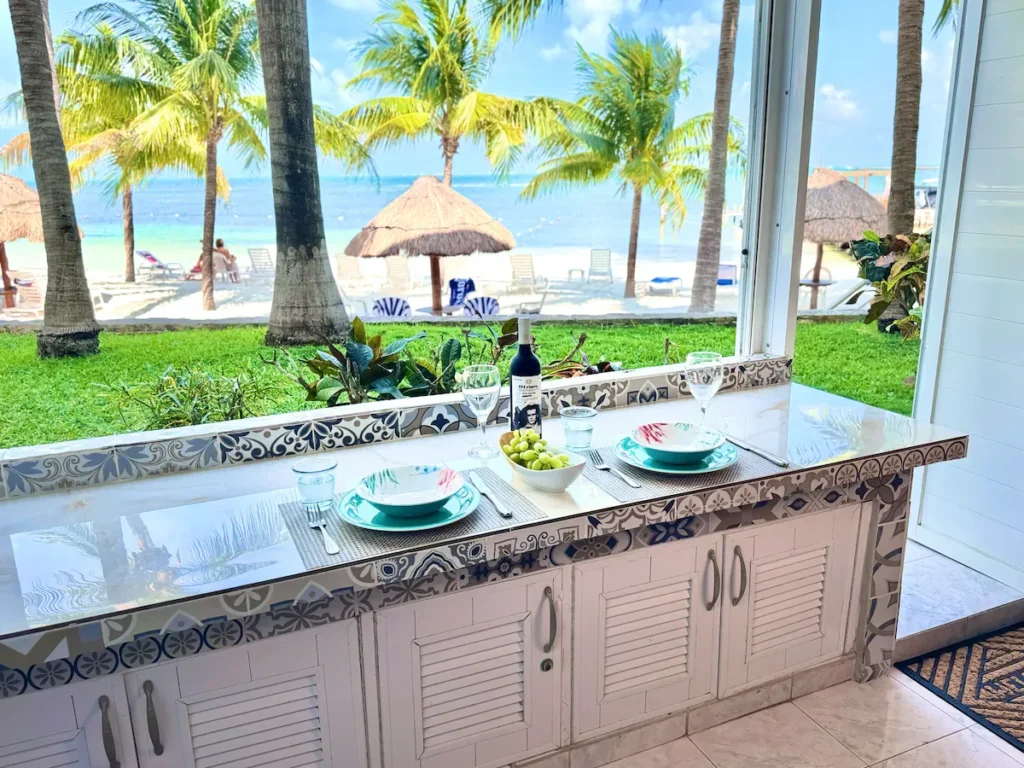 A simple table set beside palm trees and a Caribbean beach