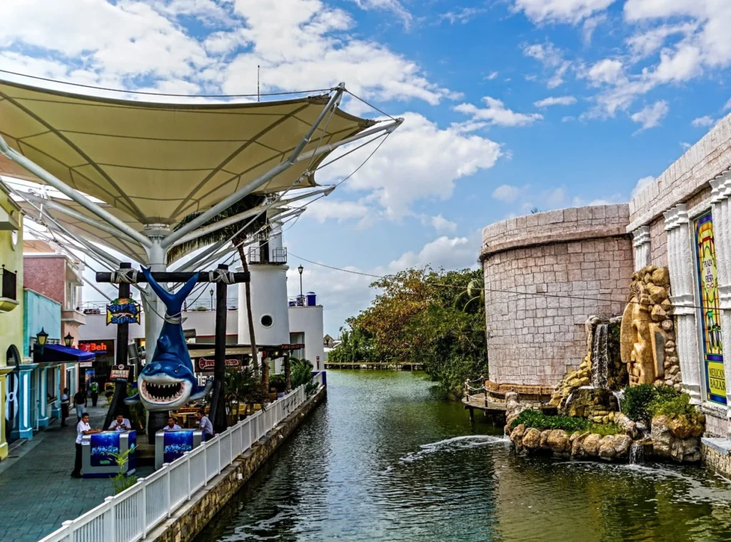 A canal and pedestrian area beneath a bright Cancún sky