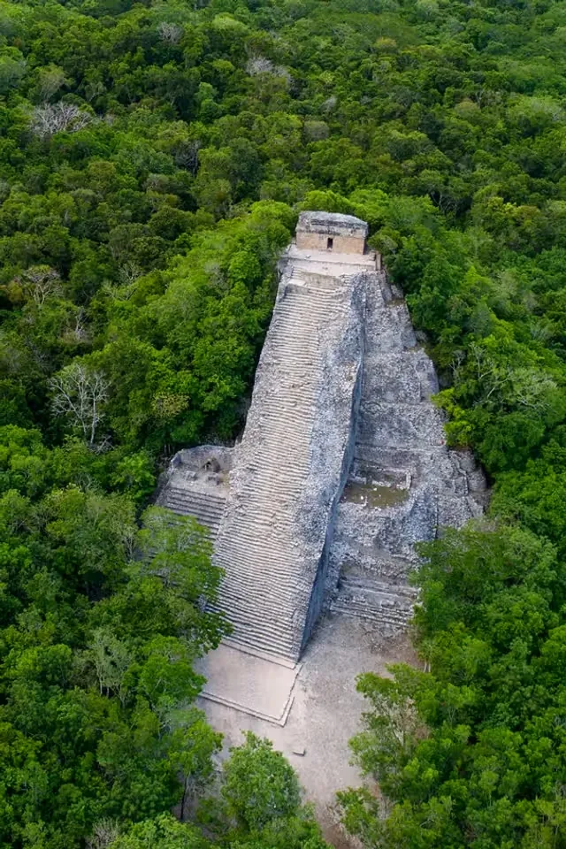 An ancient stone pyramid surrounded by dense green jungle