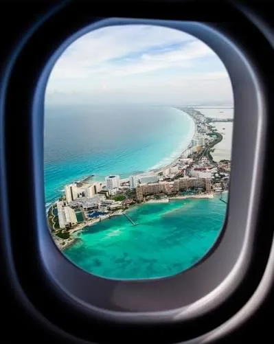 Cancún seen through an airplane window as the coastline curves along the Caribbean