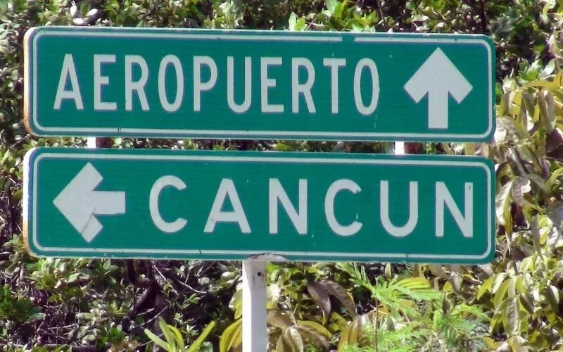 Road signs pointing toward Cancún and the airport
