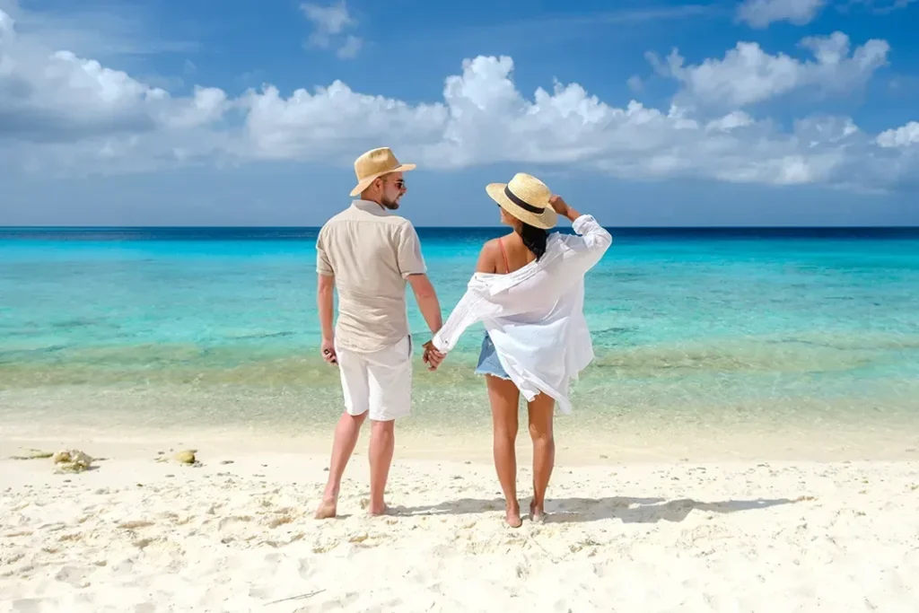 A couple standing together at the edge of turquoise water