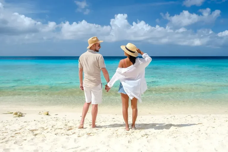 A couple standing together at the edge of turquoise water