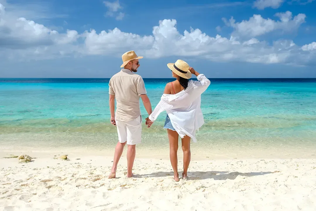 A couple standing together at the edge of turquoise water